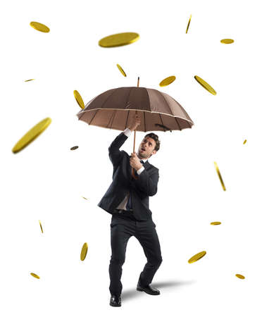 Businessman is protected by a money rainの写真素材