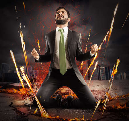 Businessman rejoices triumphantly on a city collapsingの写真素材