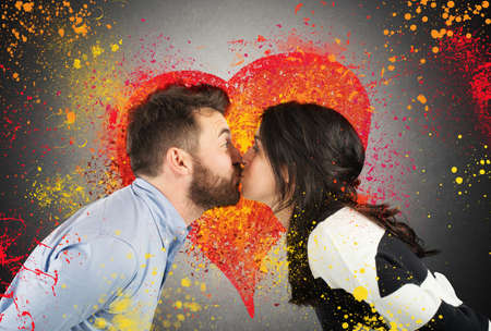 Couple kissing with splash colourful heart backgroundの写真素材