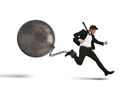 Determined businessman runs despite heavy hard impedimentの写真素材