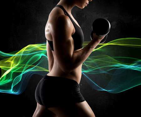 Muscular woman workout with light effect backgroundの写真素材