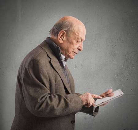 Old man surfing the internet with tabletの写真素材