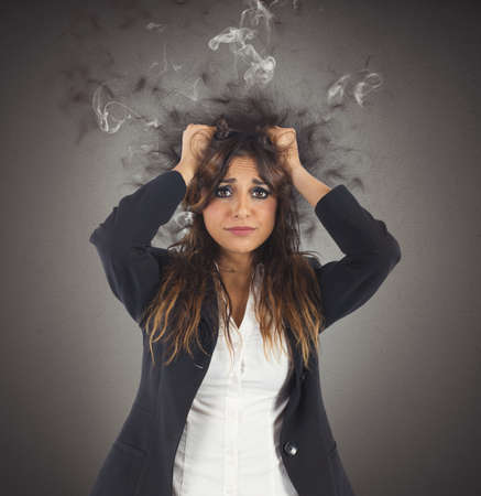 Businesswoman stressed with her head in smokeの写真素材