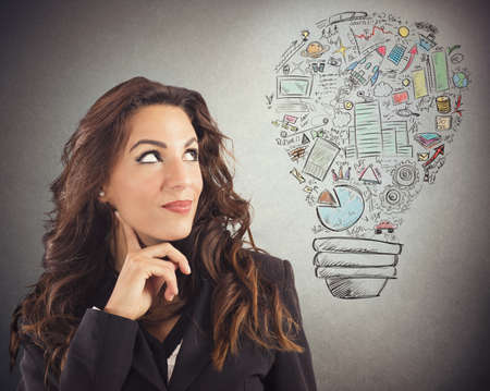 Businesswoman looking at a light bulb drawnの写真素材