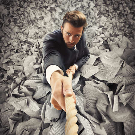 Businessman clinging to rope escape from taxの写真素材