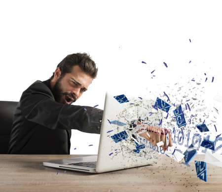 Angry businessman breaks the pc in officeの写真素材