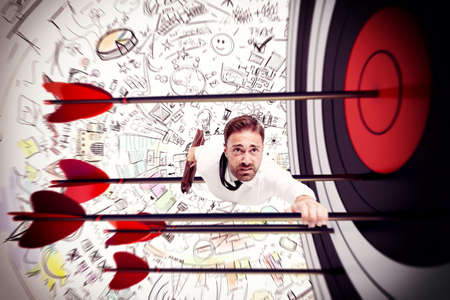Man clinging to the arrows of targetの写真素材