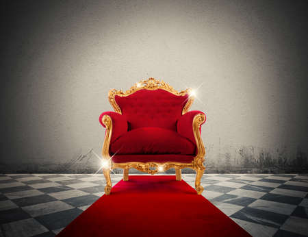 Sparkling golden armchair in a red carpetの写真素材