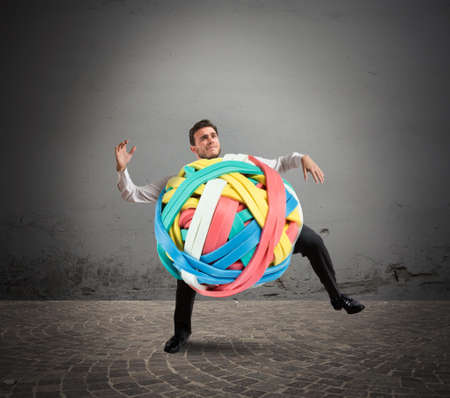 Businessman with a tangle of rubber bandsの写真素材