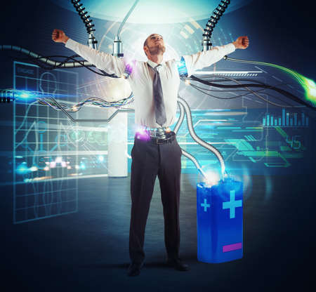 Businessman recharge his energy with a batteryの写真素材