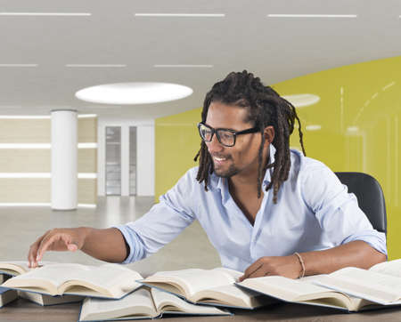 Man reads books on desk and smilesの写真素材