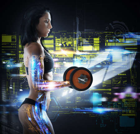 Muscular woman trains while the monitor technologicallyの写真素材
