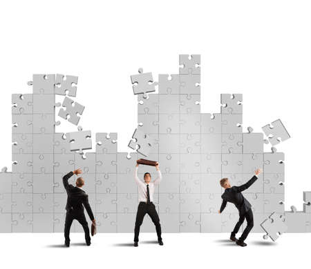 Businessmen are repaired by falling puzzle piecesの写真素材