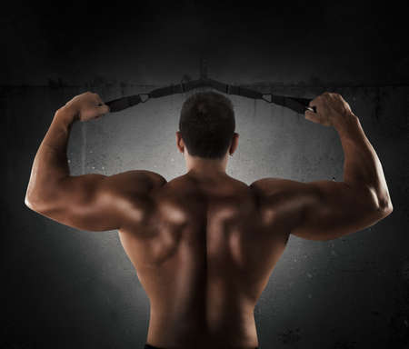 Man trains the shoulder muscles with trxの写真素材