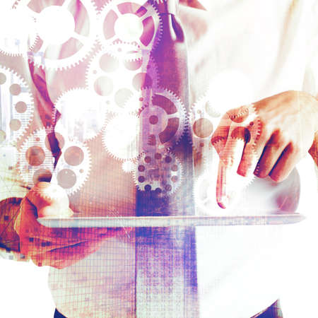 Businessman with tablet in the gear backgroundの写真素材