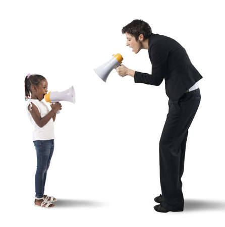 Child screaming on the megaphone to womanの写真素材
