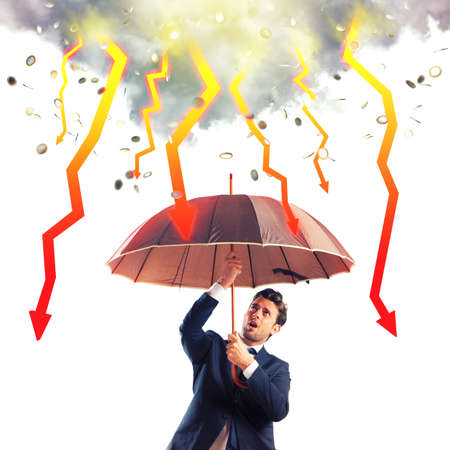 Businessman sheltered with umbrella from lightning arrowの写真素材