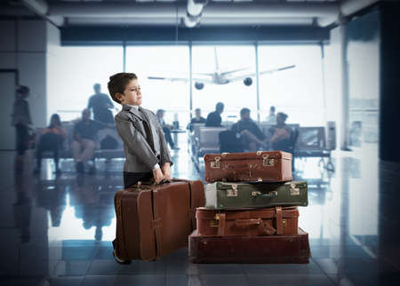 Child with so many suitcases inside airportの写真素材