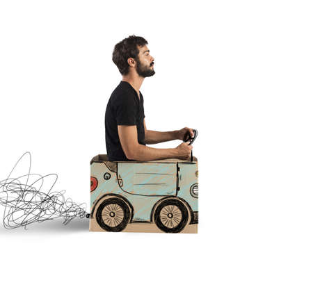 Boy driving a fake designed cardboard car