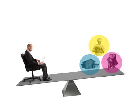 Businessman with laptop sitting on a balanceの写真素材
