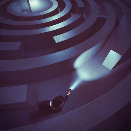 Man with flashlight in a dark mazeの写真素材