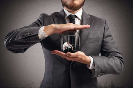 Boss holds in hands a caged manの写真素材