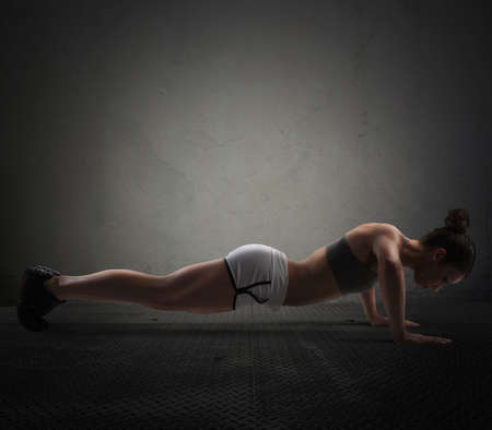 Athletic girl is training doing push upの写真素材