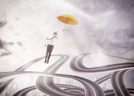 Businessman flying above a maze of streetsの写真素材
