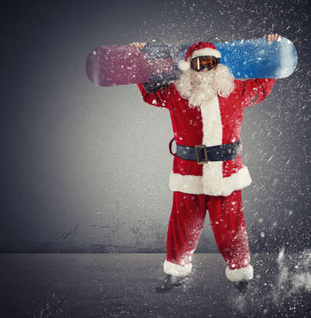 Santa Claus with snowboard during a snowfallの写真素材