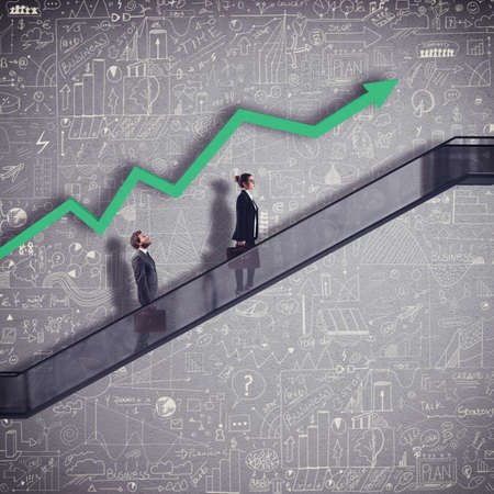 Businesspeople in an escalator with arrow growingの写真素材