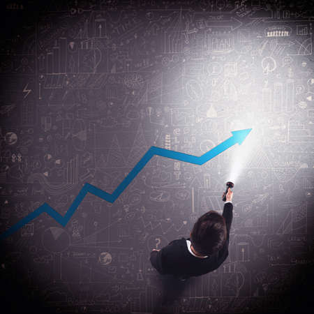 Businessman lights with a torch an arrowの写真素材