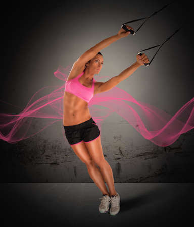 Woman fitness instructor training with the TRXの写真素材