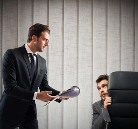 Fearful of boss employee is behind a chair