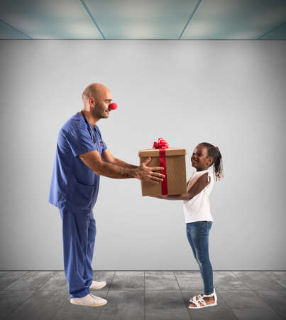 Clown nurse makes gift to a childの写真素材