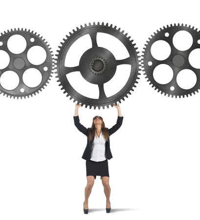 Businesswoman holding a gear among other gearsの写真素材