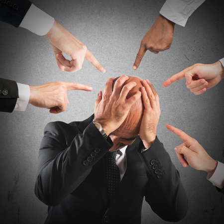Desperate businessman pointed to by many fingers
