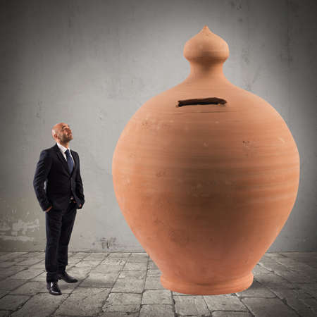 Satisfied businessman looks a big money bankの写真素材