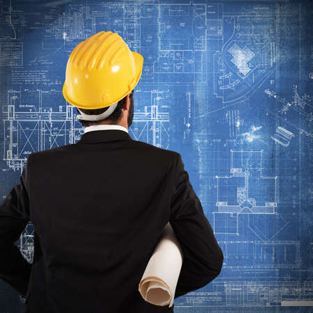 Man architect looks at a building projectの写真素材