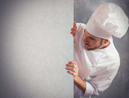 Man chef looks at a big billboardの写真素材