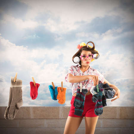 Vintage housewife with curlers stretches the laundryの写真素材