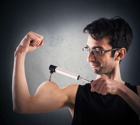 Man inflates his muscles with a pumpの写真素材
