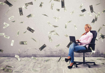 Businesswoman working at pc with banknotes backgroundの写真素材