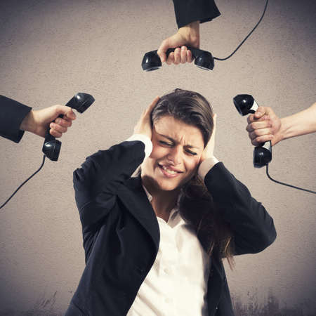 Businesswoman stressed and annoyed by business callsの写真素材