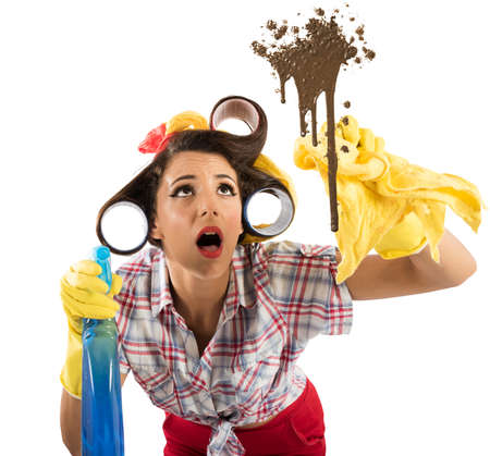 Housewife with spray cleaning a dirty glassの写真素材