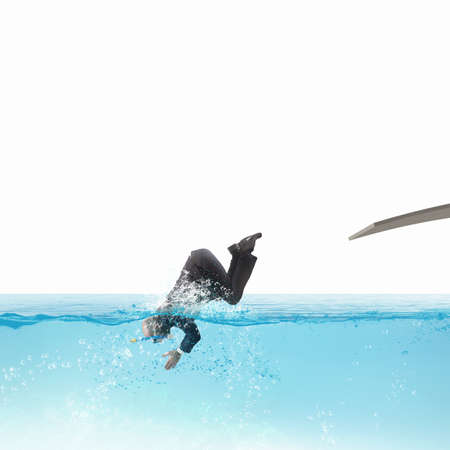 Businessman with suit dives into the poolの写真素材