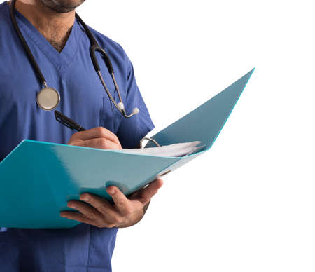 Doctor with stethoscope writes on medical recordの写真素材