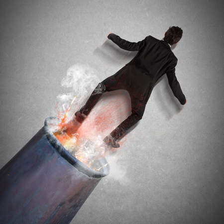 Businessman is shot out of a cannonの写真素材