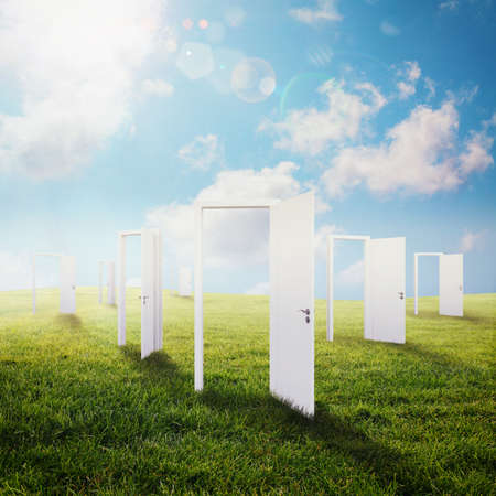 White doors open on a green meadowの写真素材