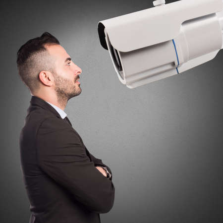 Man looks at a big surveillance cameraの写真素材