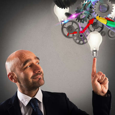 Man with light bulbs and gear mechanismsの写真素材